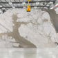 Large white marble slab with grey and gold veining in indoor slab yard