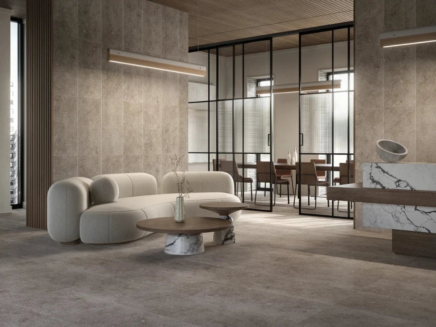 Modern interior with a beige sofa, marble floors and walls and glass walls.