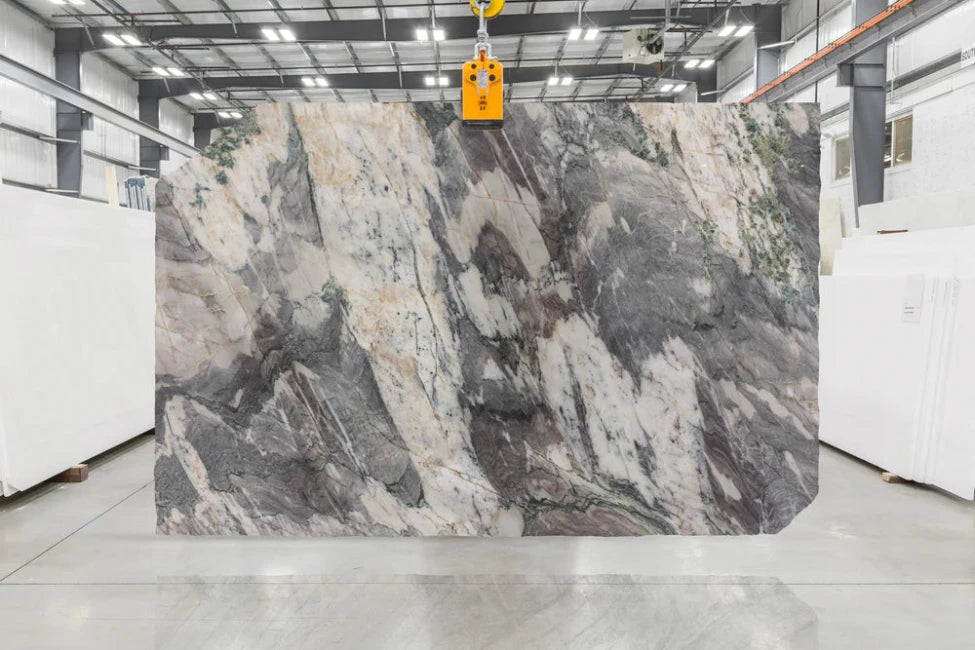 Large slab of marble with a gray and white pattern in indoor slab yard