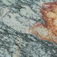 A close-up of a quartzite stone surface with a mottled pattern of pale blue-green, gray, and rust-orange veining.