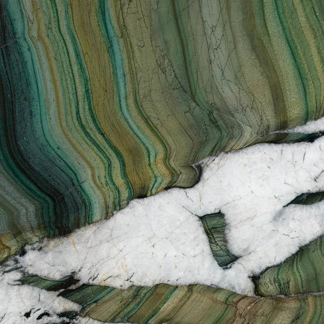 A close-up of a polished quartzite stone with wavy bands of green, teal, olive, beige, and white, including a prominent white fractured area running diagonally across the lower middle.