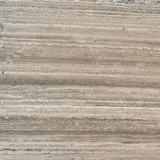 A close-up texture of a travertine stone slab surface with horizontal striations in warm beige, taupe, and light brown tones.