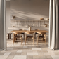 Dining area with wooden table and chairs in a modern kitchen and beige porcelain tiles.