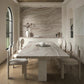 Modern dining room with travertine table and chairs, stone wall, and large window.