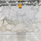white marble with green and gold veining in slab yard